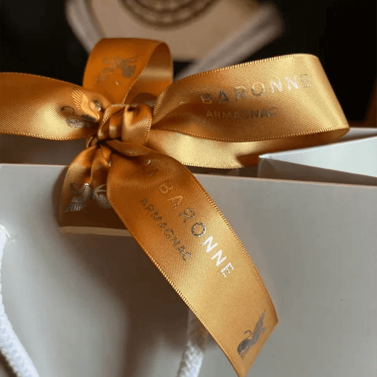 Elegant La Baronne Armagnac gift box with a golden ribbon, showcasing premium branding and craftsmanship.