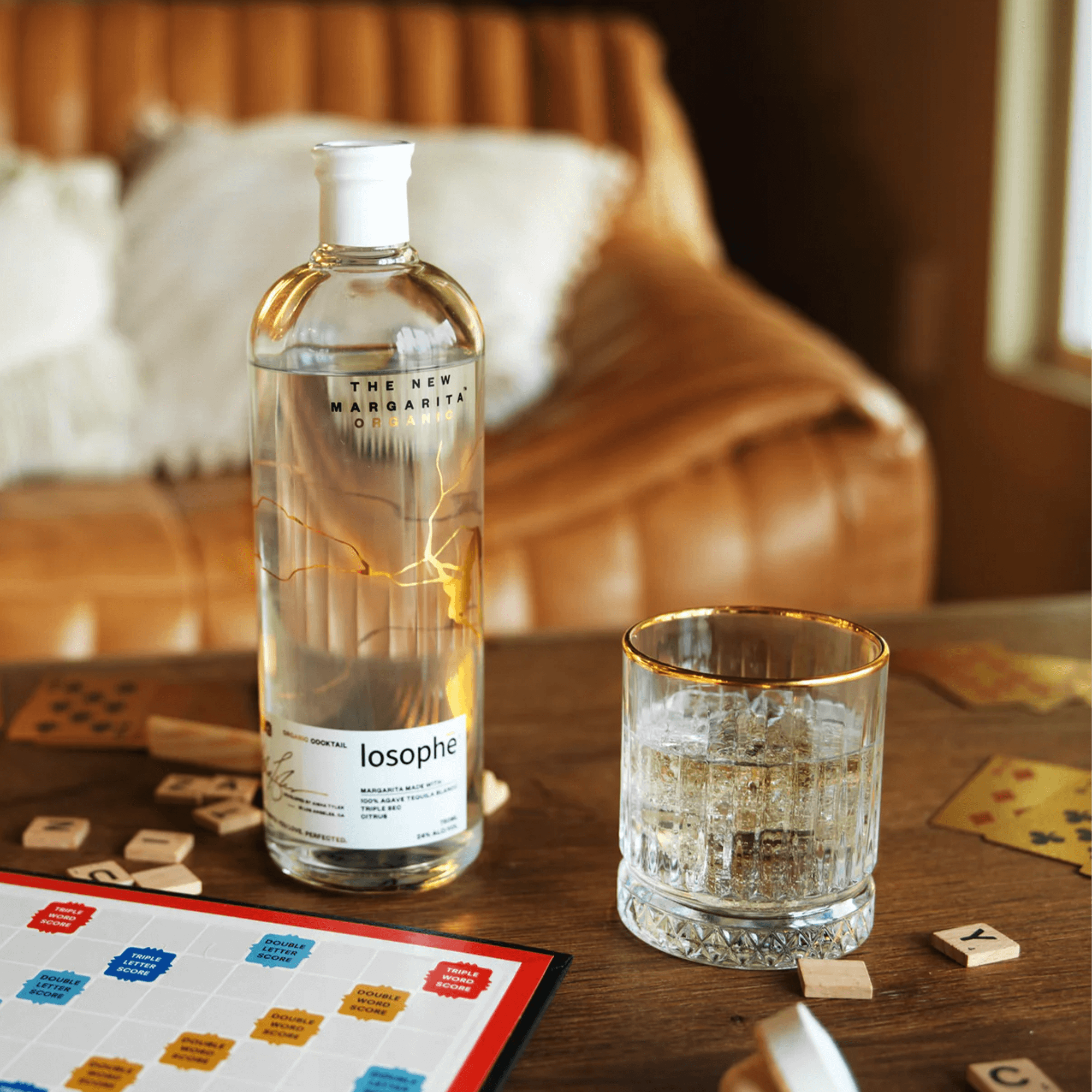 Losophe Margarita bottle with glass on a wooden table, perfect for enjoying cocktails with friends.