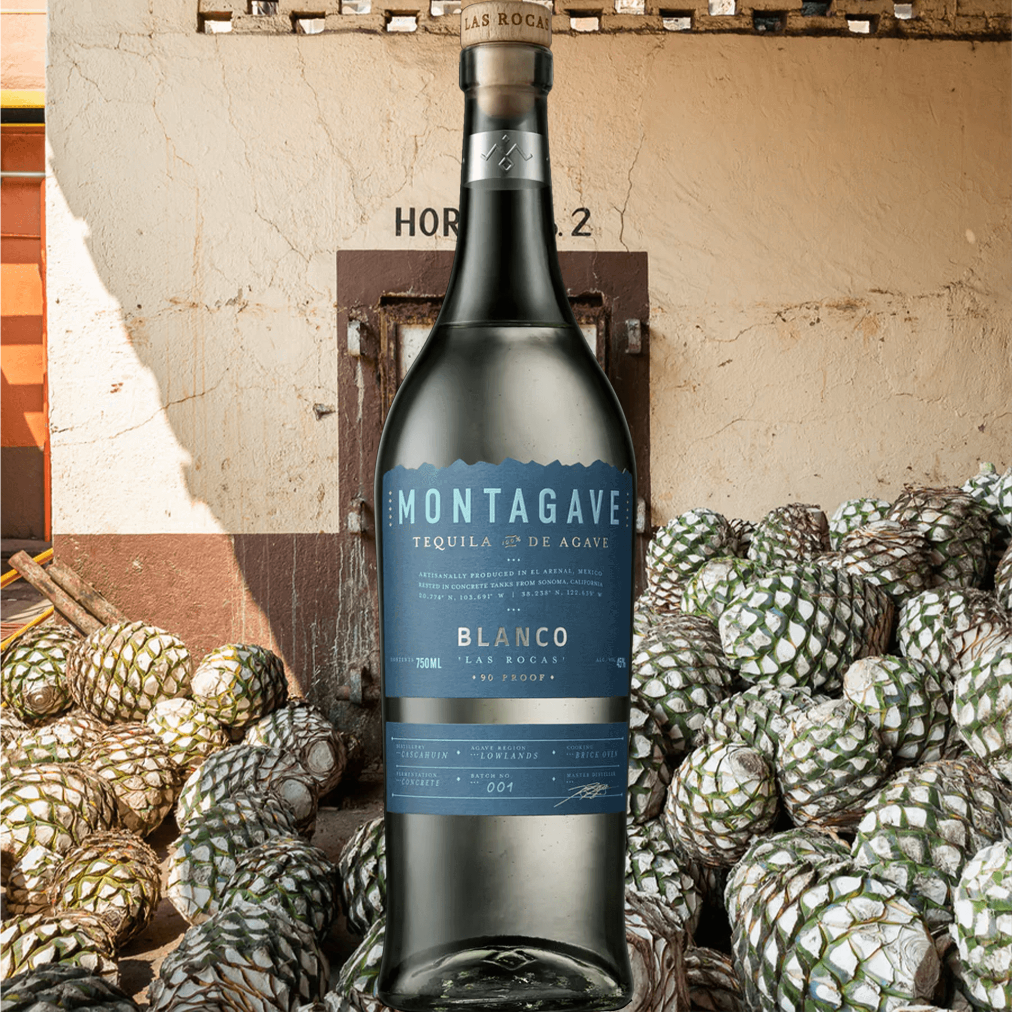 Montagave Las Rocas Blanco Tequila bottle in front of agave plants, showcasing its unique concrete egg aging method.