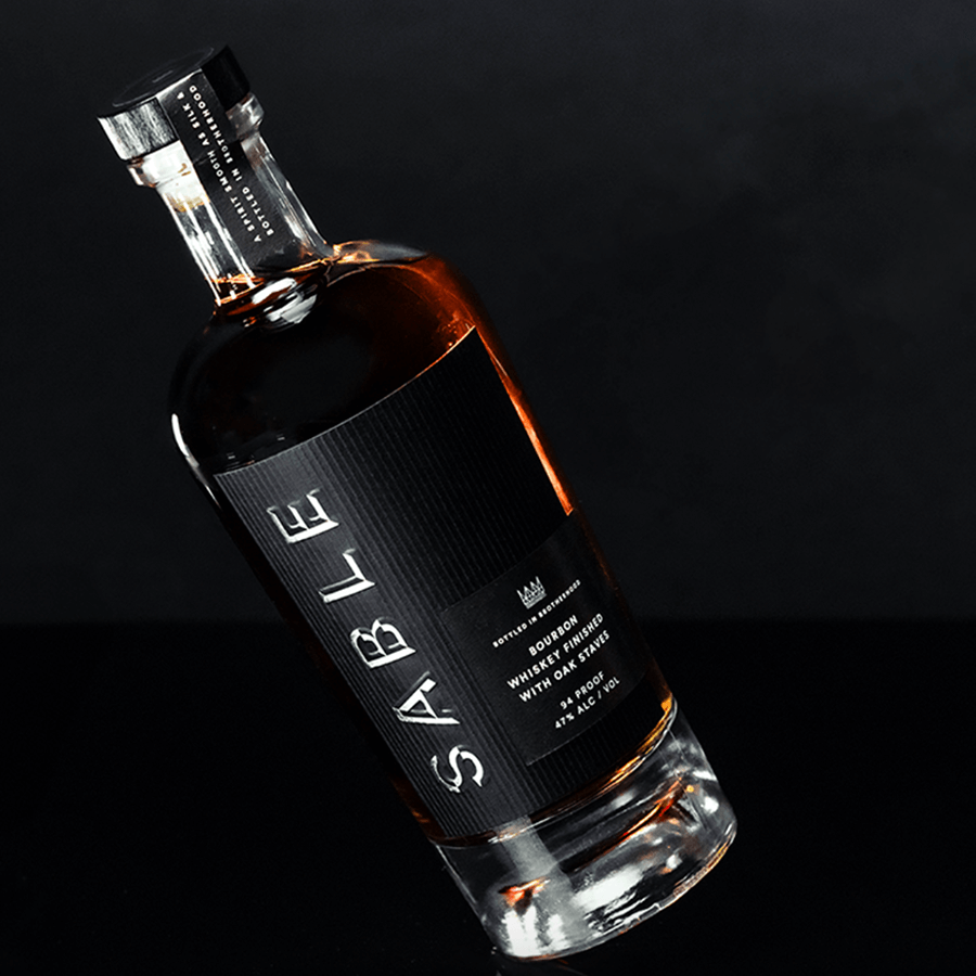 Sable Bourbon bottle showcasing rich amber color and elegant label design on a dark background.