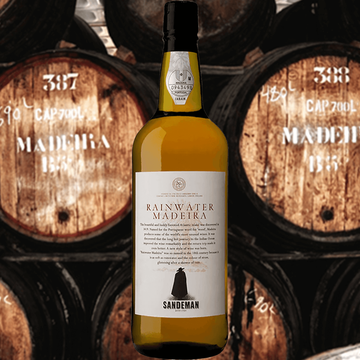 Sandeman Madeira Rainwater bottle with aged wine barrels in the background, depicting traditional winemaking.