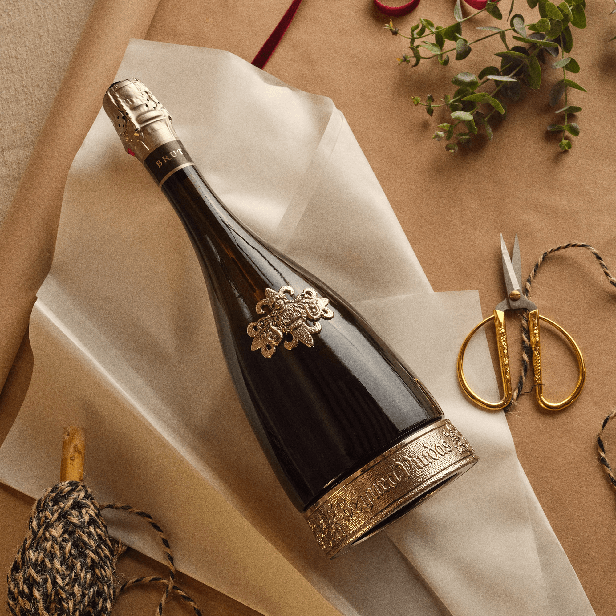 Elegant Segura Viudas Reserva Heredad Brut bottle on wrapping paper with scissors and twine.