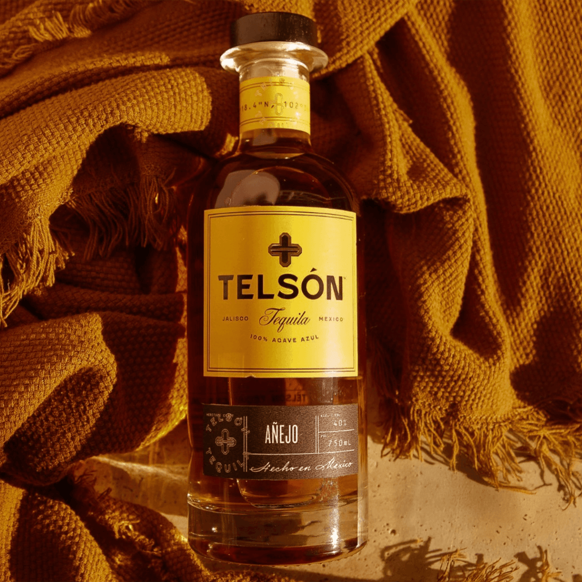 Telsón Añejo Tequila bottle on a textured background, showcasing its rich amber color and elegant label.