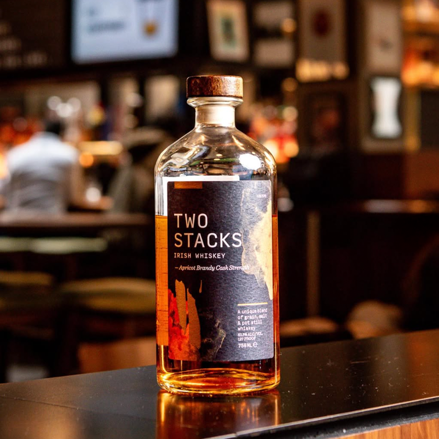 Two Stacks Brandy Cask Strength Whiskey bottle displayed on a bar countertop with a blurred background.
