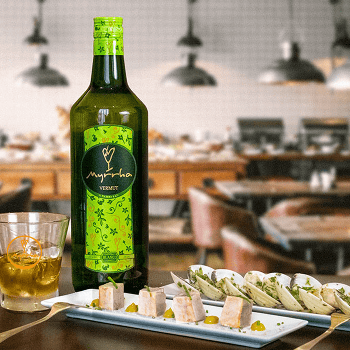 Vermut Padró & Co. Myrrha Blanco 1L bottle with tapas on a bar table in a cozy restaurant setting.