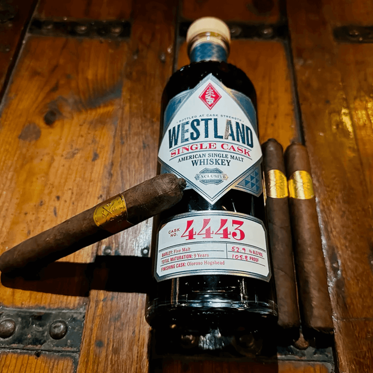 Westland Single Cask #4443 whiskey bottle, paired with premium cigars on wooden surface for a holiday indulgence.