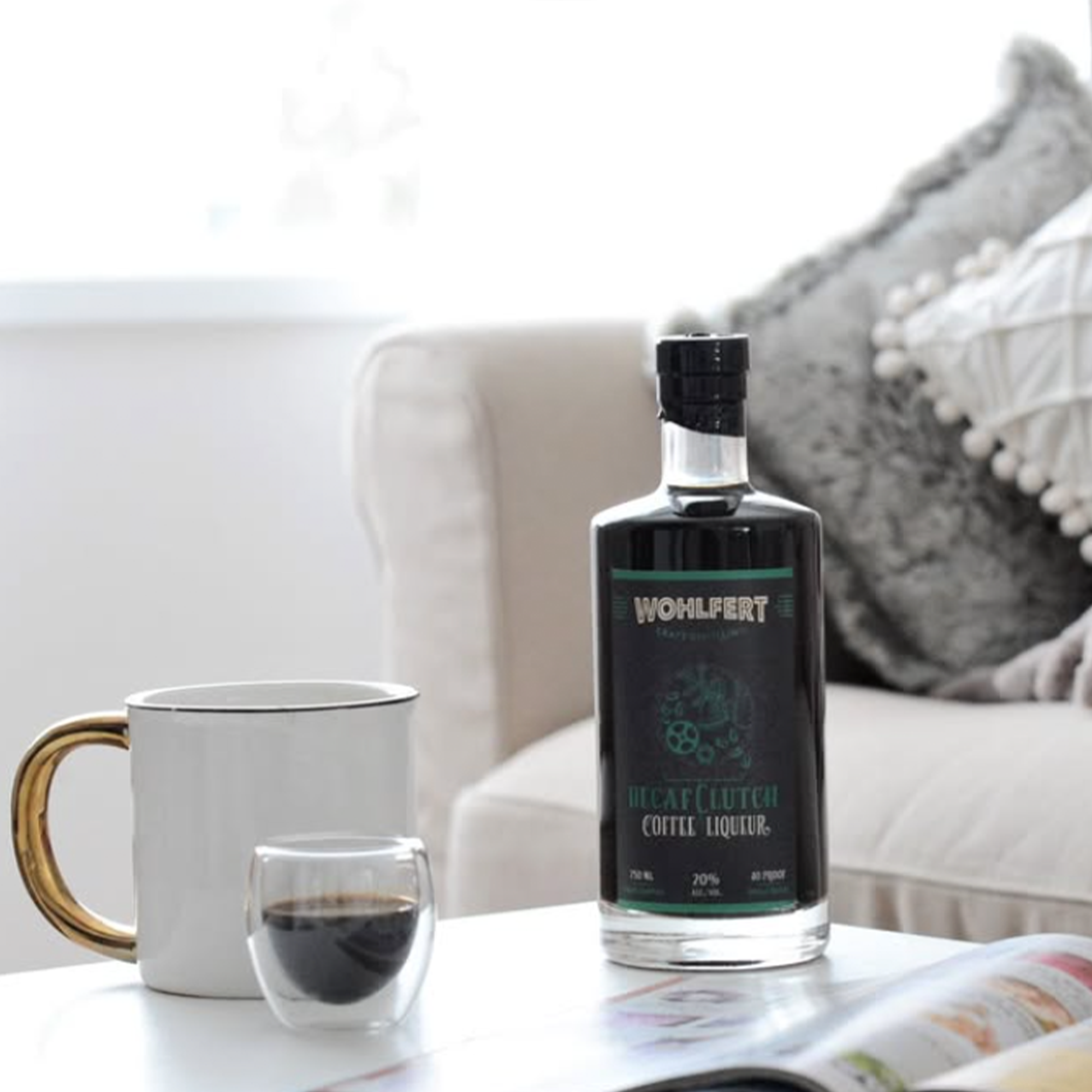 Wohlfert Decaf Clutch Coffee Liqueur bottle beside a cup of coffee on a cozy table setting.