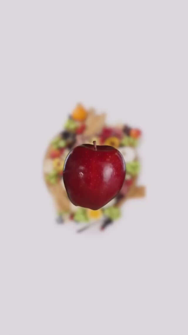 Fresh red apple isolated over a colorful salad, showcasing healthy eating and vibrant ingredients.