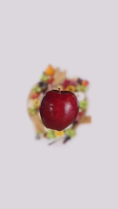 Fresh red apple isolated over a colorful salad, showcasing healthy eating and vibrant ingredients.