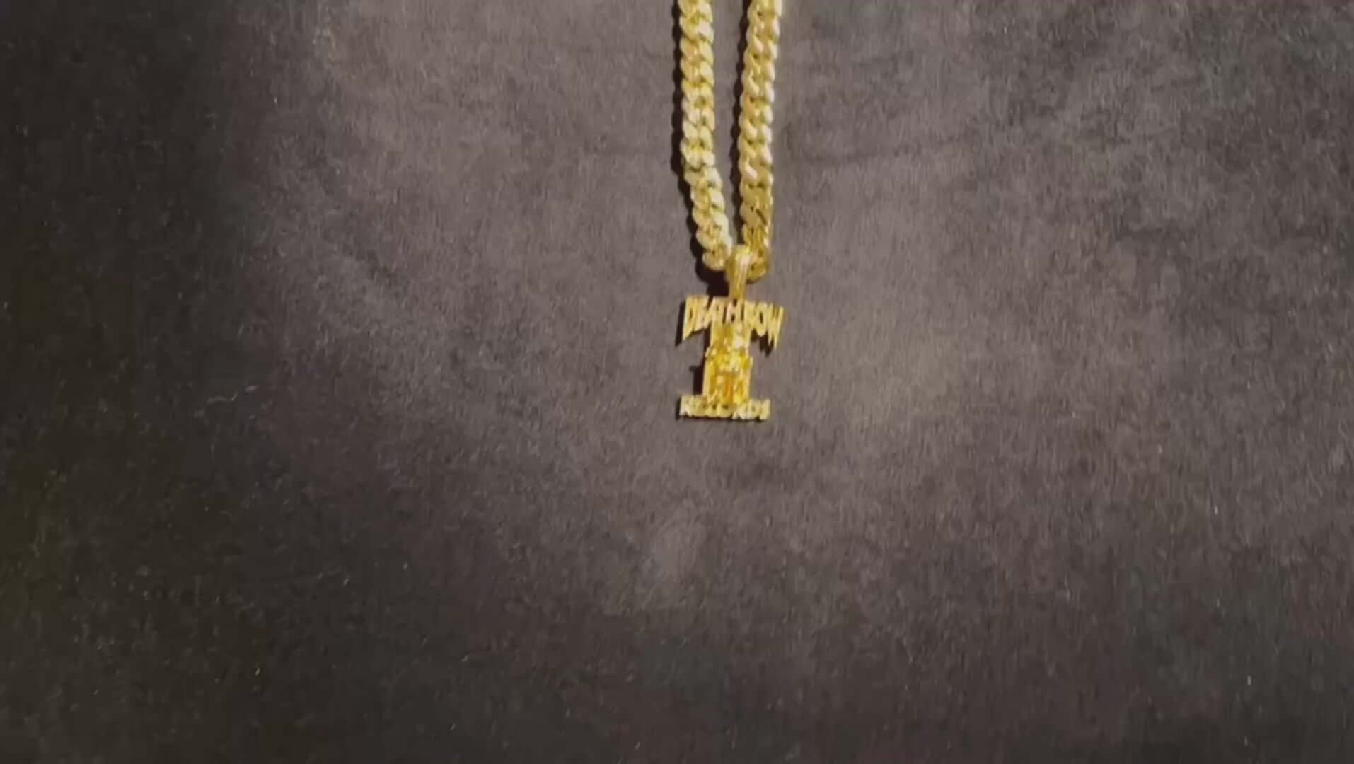 Gold necklace with pendant on a dark background showcasing intricate design and shine.